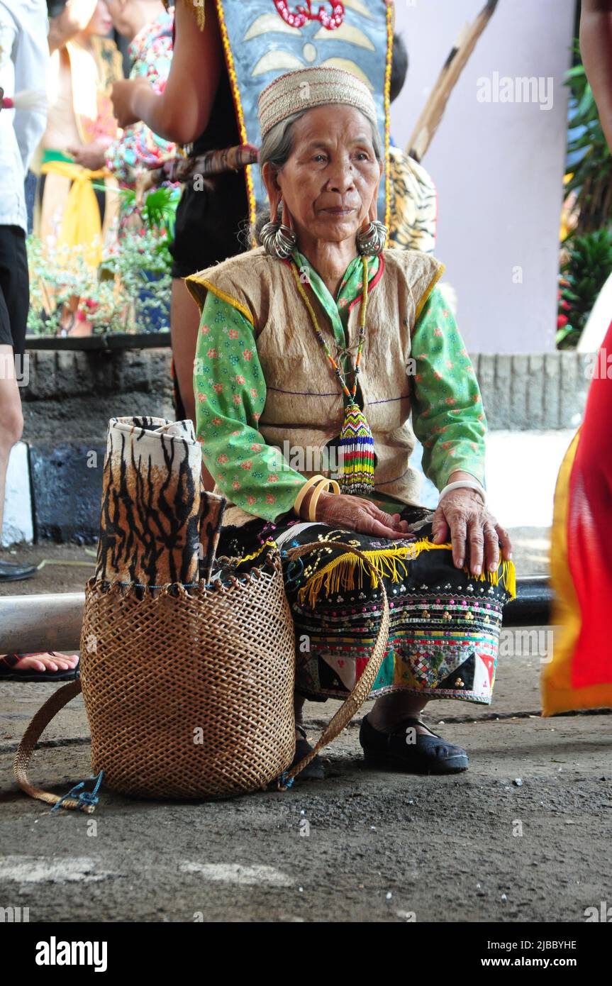 Jakarta, Indonesia - April 28, 2013 : An old woman from the Dayak tribe of Borneo, Kalimantan is sitting waiting for the opening of the Dayak Festival Stock Photo