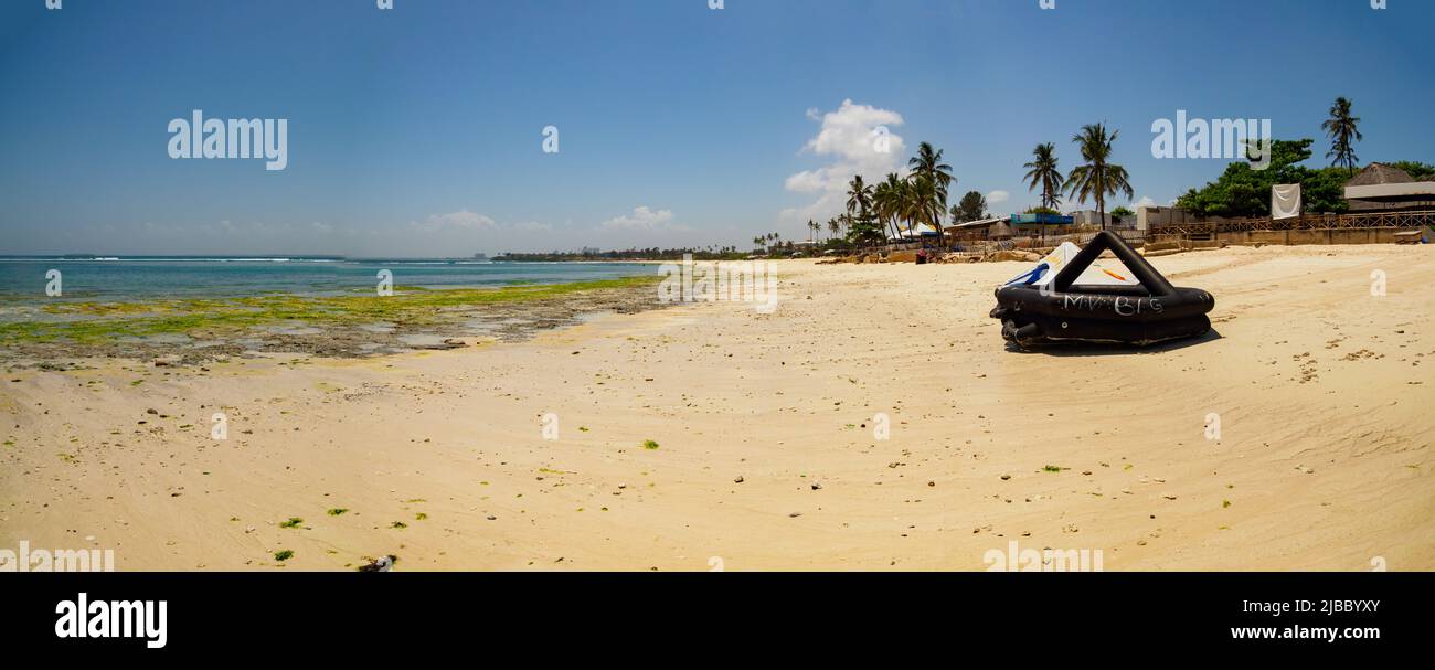Dar es Salaam, Tanzania - February 2021: Coco Beach on a hot day at low tide and black inflatable boat. Covid time in Africa. Stock Photo