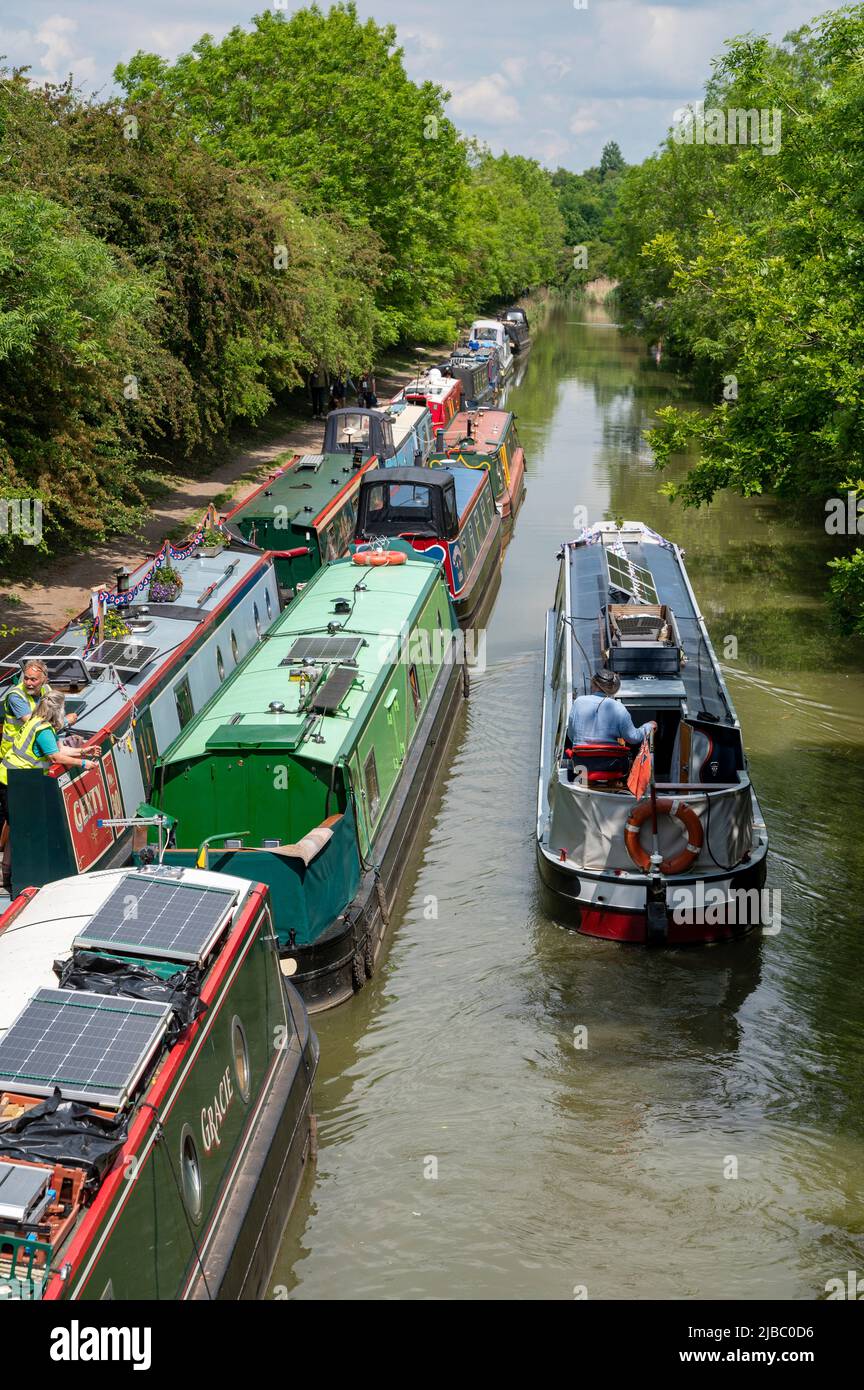 Looking down on a narrowboat passing a large number of moored boats on the Grand Union Canal near Crick in Northamptonshire. Stock Photo