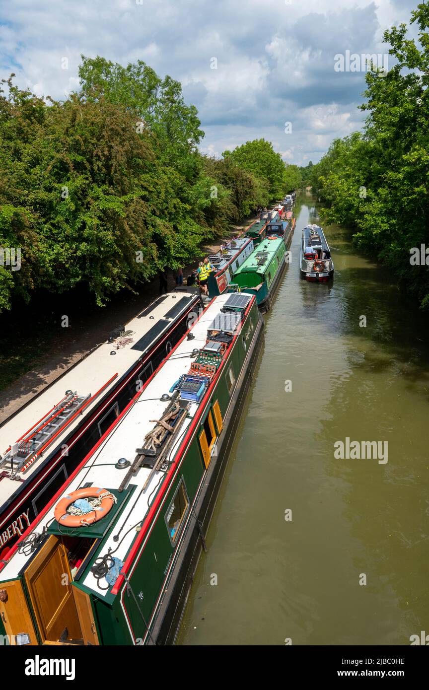 Looking down on a narrowboat passing a large number of moored boats on the Grand Union Canal near Crick in Northamptonshire. Stock Photo