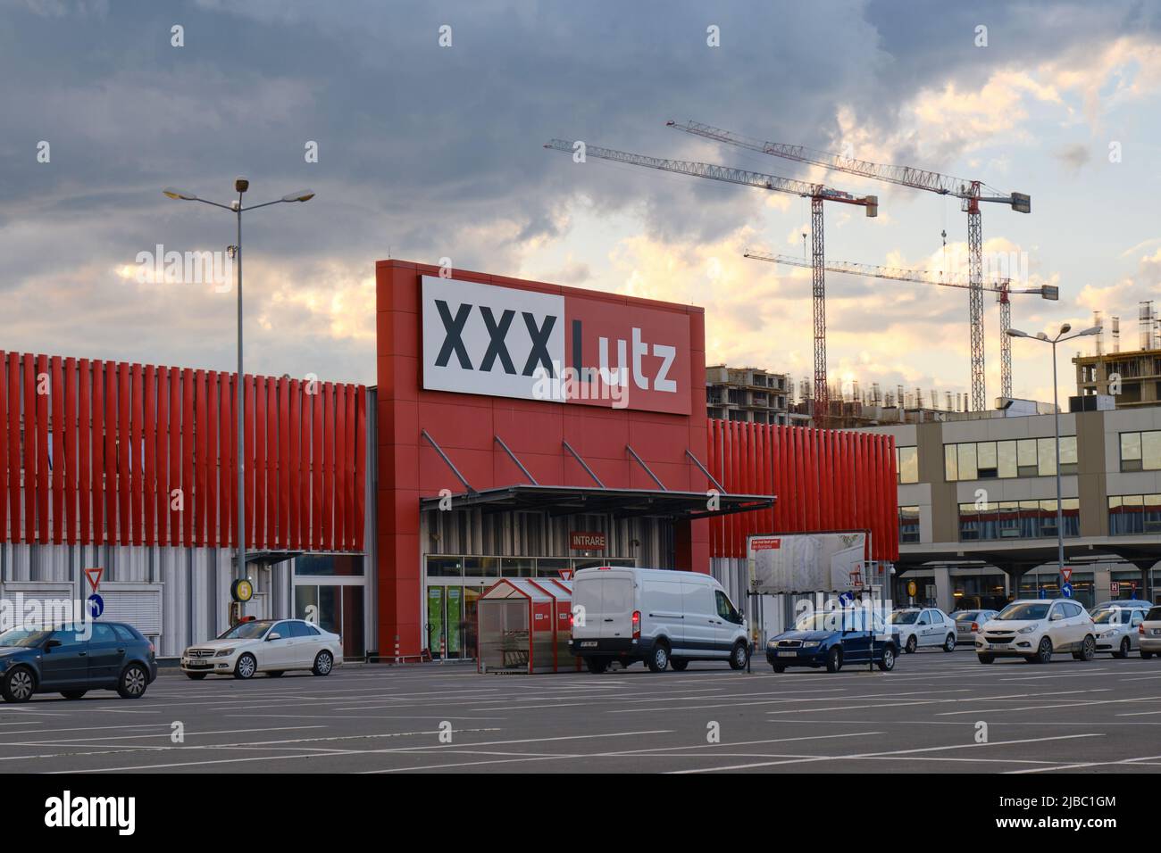 XXXLutz logo sign, parked cars and evening clouds. XXXLutz Group is an Austrian furniture store chain with headquarters in Austria. Bucharest, Romania Stock Photo