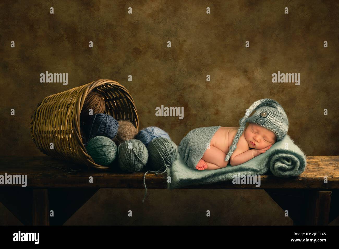 Adorable little newborn baby boy of only 11 days old sleeping on soft blue knitted wool Stock Photo