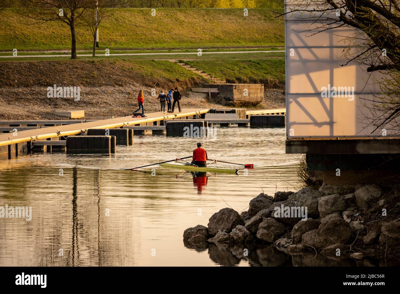 Zagreb, Croatia-April 1st, 2022: Man in the kayak rowing at the jarun lake, Croatia with new docks being recently built by the shore Stock Photo