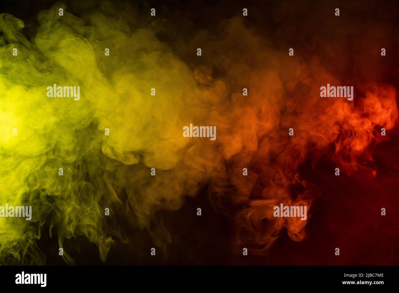 Red-yellow smoke spreads on a black background Stock Photo - Alamy