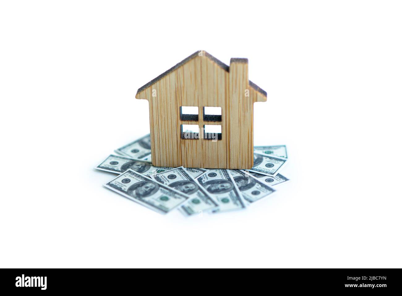 Toy small house standing on a heap of coins. The concept of purchase of habitation Stock Photo