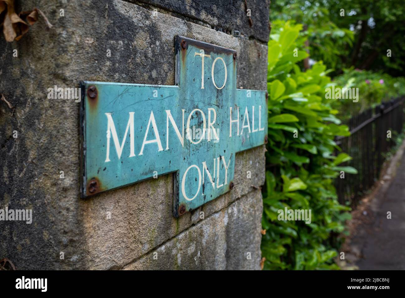 Old weathered sign To the Manor Hall Only (Jun22 Stock Photo - Alamy