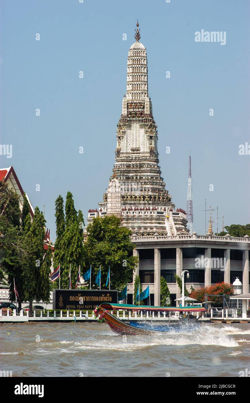 Wat Arun, the Temple of Dawn, by the Chao Phraya River with a passing boat, Bangkok, Thailand Stock Photo