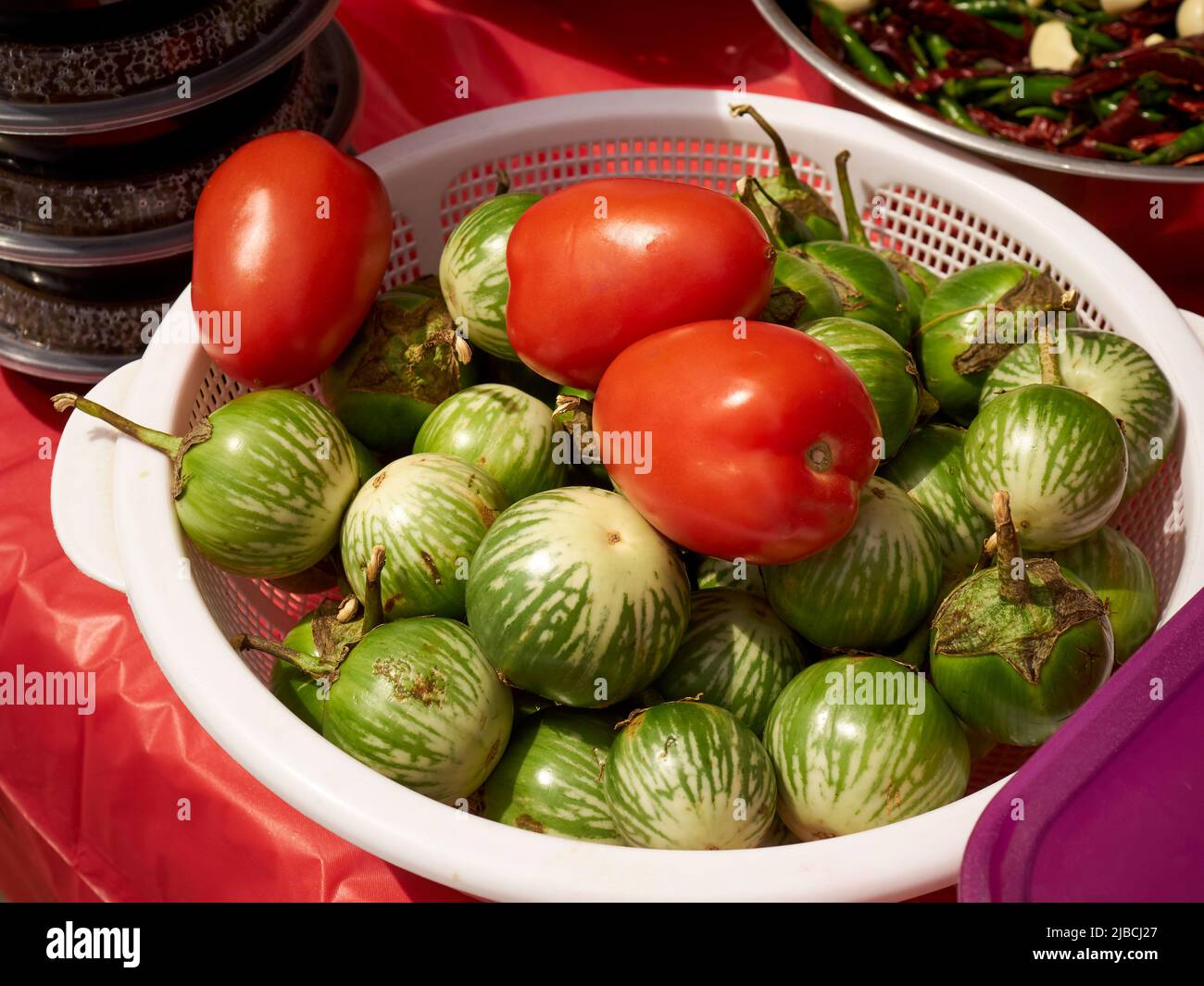A bowl of tomatoes and eggplants for a som tum salad on a street vendor cart, Little Thailand, Queens, New York City, USA Stock Photo