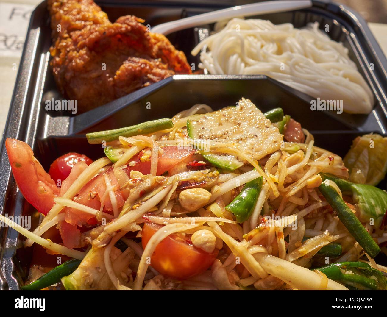 Som tum, noodle and fried chicken platter from a street vendor in Little Thailand, Queens, New York City, Festival Stock Photo