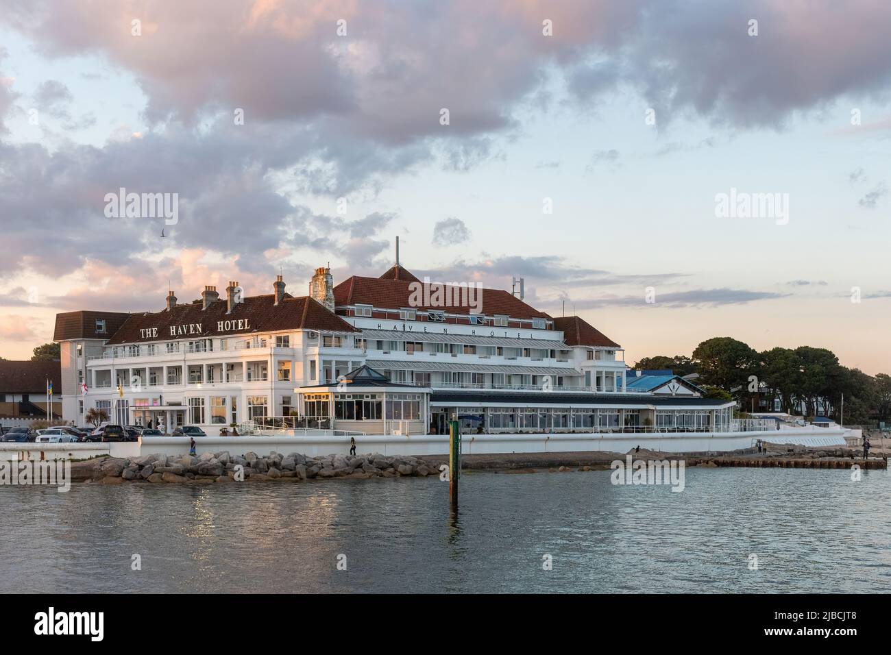 The Haven Hotel on Sandbanks peninsula, Poole Harbour, Dorset, England, UK, viewed from the sea at sunset Stock Photo