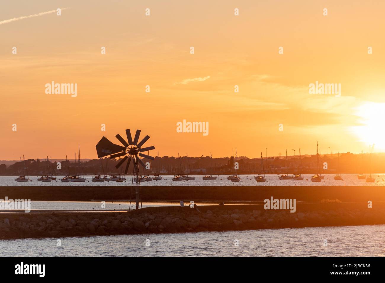 Sunset over Poole Harbour and Brownsea Island lagoon and windpowered