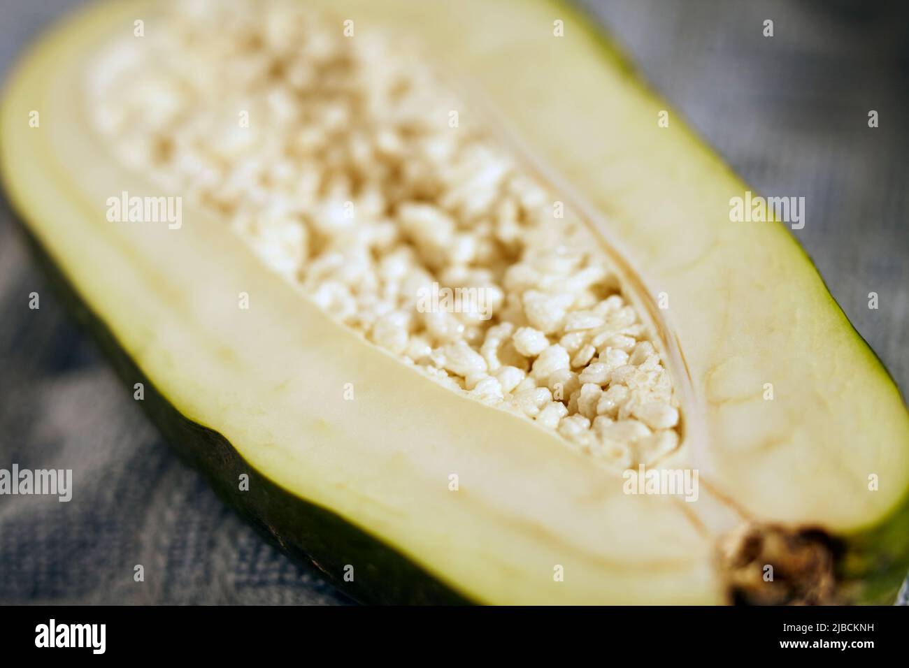Green papaya sliced in half showing the seeds Stock Photo