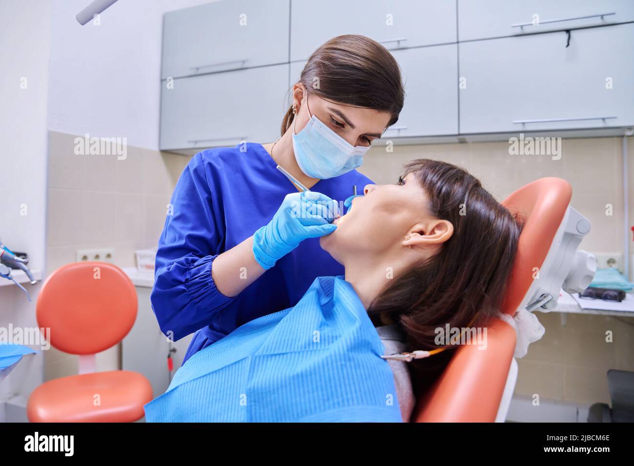 Woman patient treating teeth in clinic, treatment process Stock Photo