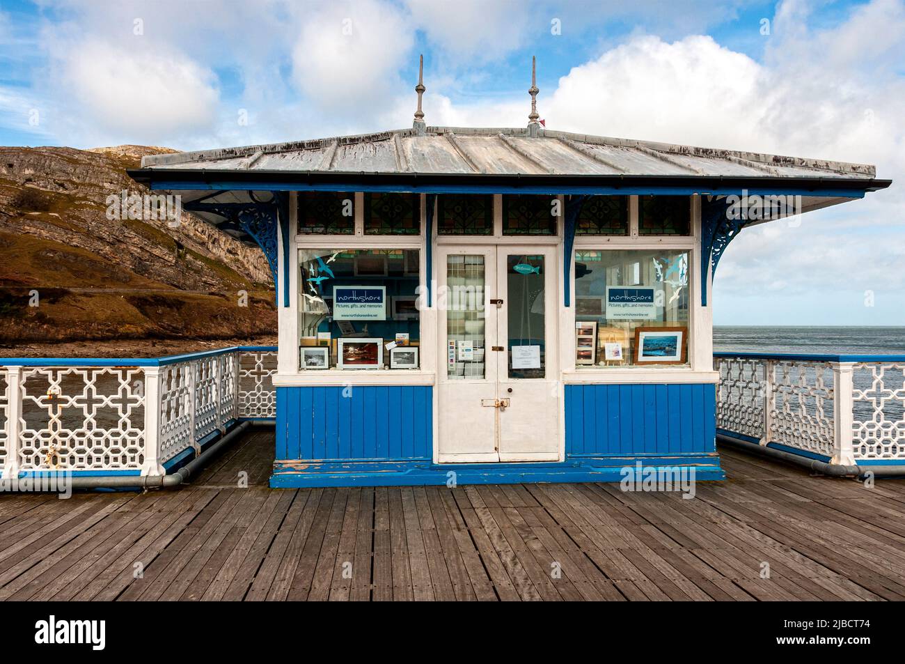 A blue and white painted wooden gift shop with windows and a hipped roof with overhanging eaves on the decking of the Grade ll listed Victorian Pier Stock Photo