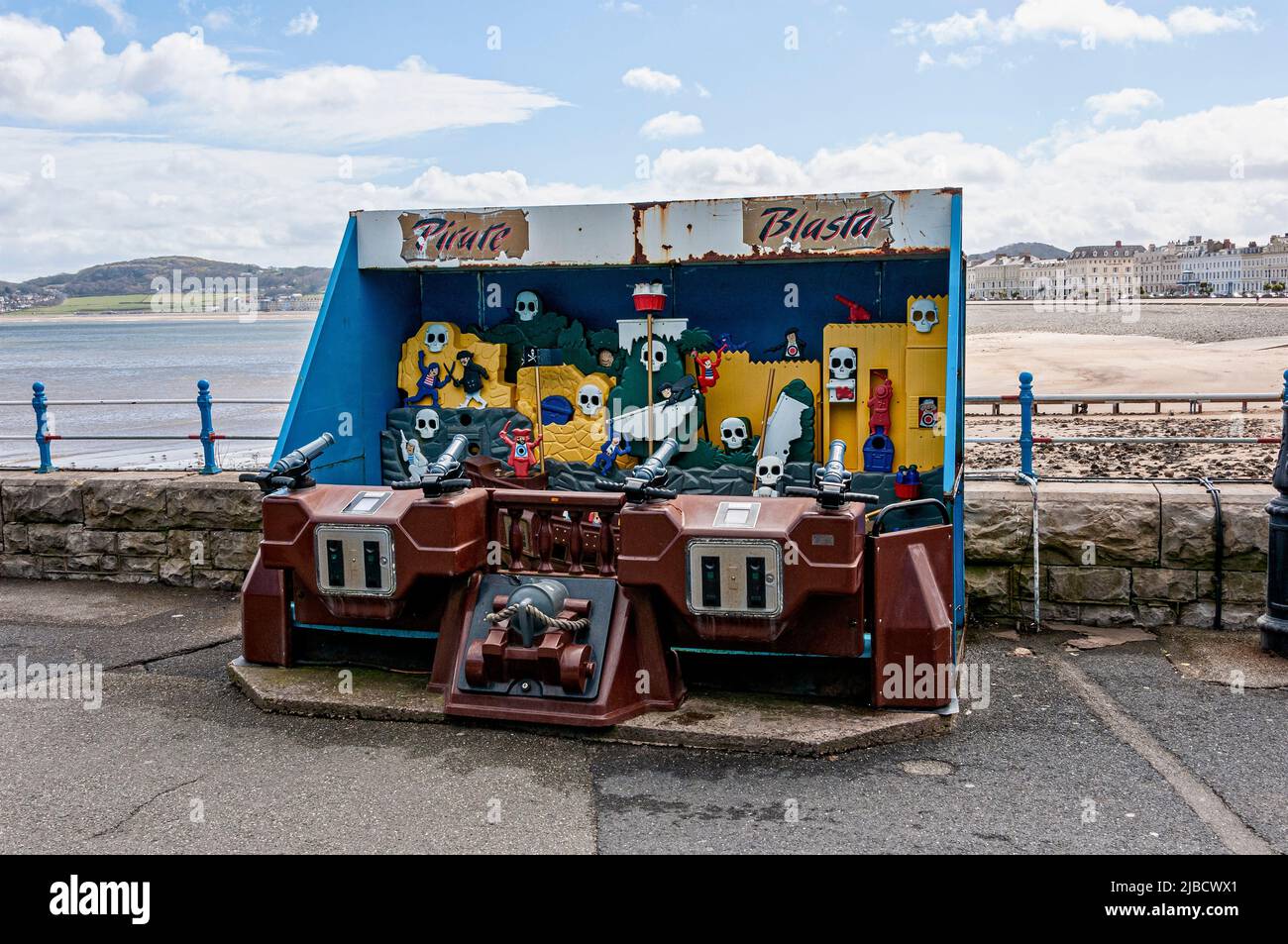 A brown children and adults amusement game blasting jets of water at skulls and other objects just before the entrance to the Victorian Llandudno Pier Stock Photo