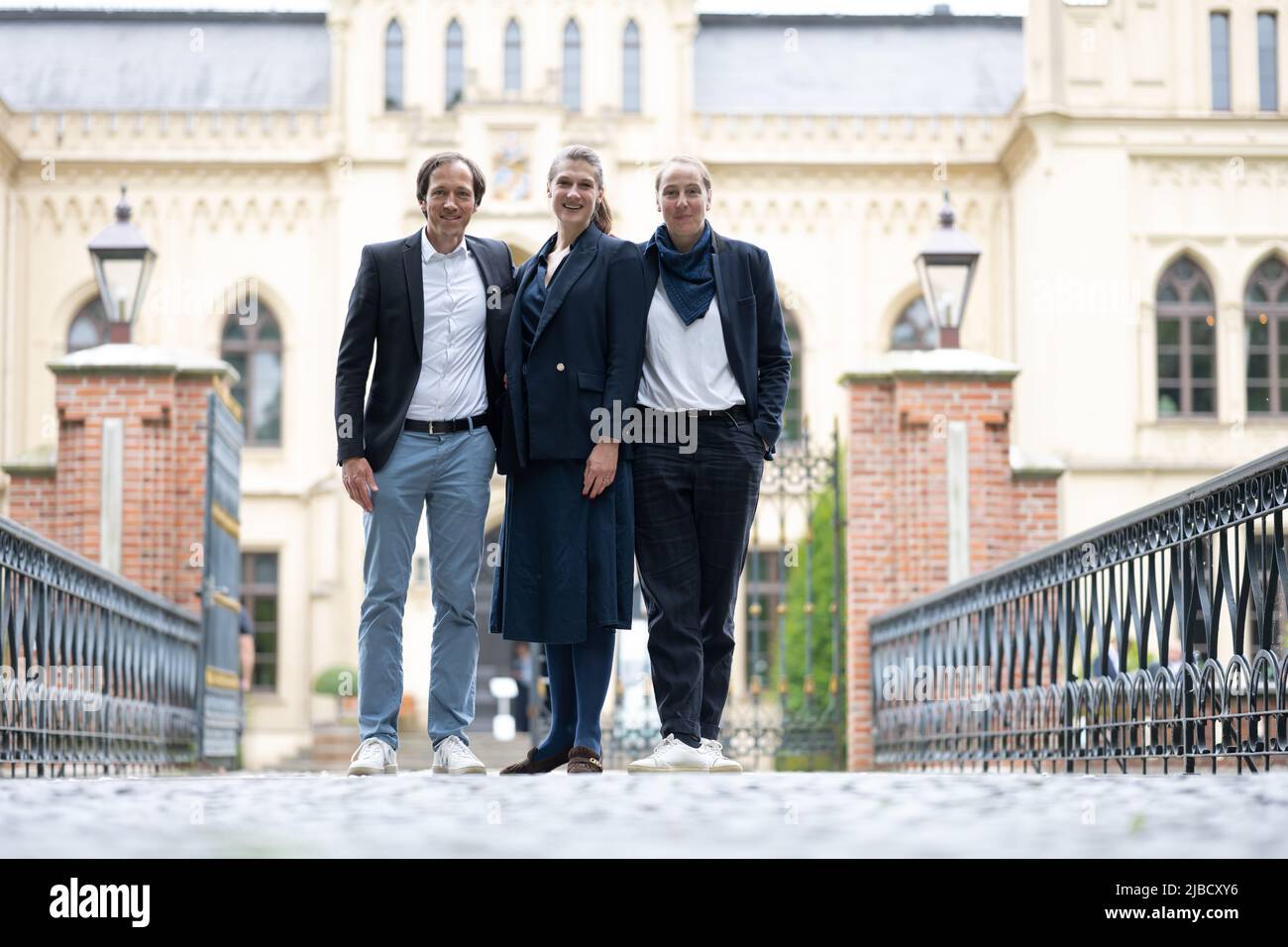05 June 2022, Lower Saxony, Leer: Willem Julius Müller (l-r), Ina Grätz and Silke Oldenburg, board members of the Ostfriesland Biennale, stand in front of Evenburg Castle in Leer. The first edition of the Ostfriesland Biennale around Ems and Dollart opened on the Whitsun weekend. Photo: Lars Klemmer/dpa Stock Photo