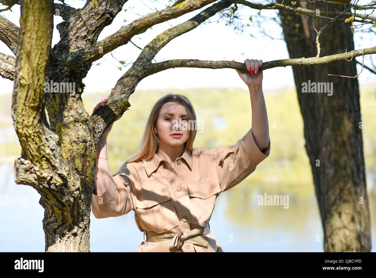 Girl in a jacket near a tree in the forest near the lake Stock Photo ...