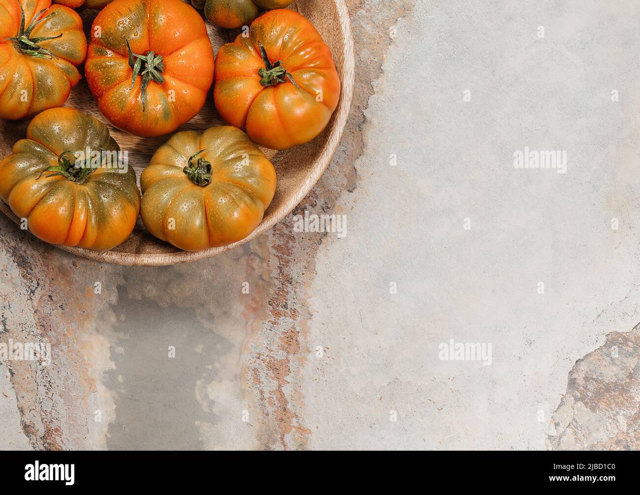 A group of Costoluto big tomatoes on a brown background Stock Photo - Alamy