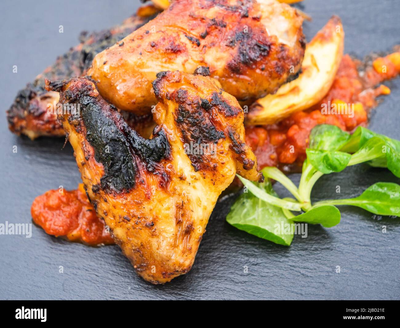 Grilled Hot Chicken Wings with Potato Wedges, a Spicy Dip and Field Salad Stock Photo