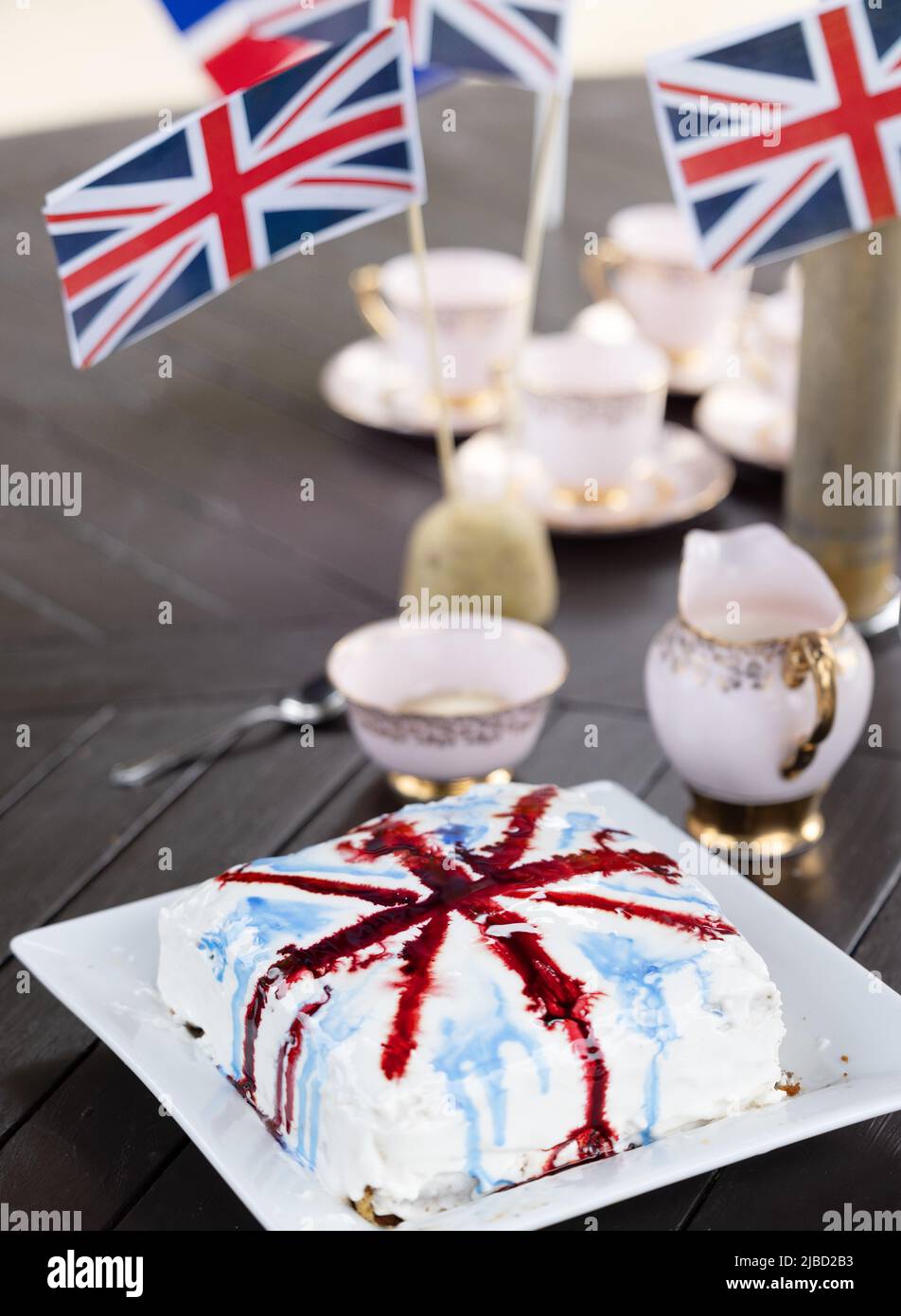 Concept Britishness,  British; bone china tea cups, union jacks, the flag of the UK, and cake as part of the Platinum Jubilee celebrations, Suffolk UK Stock Photo