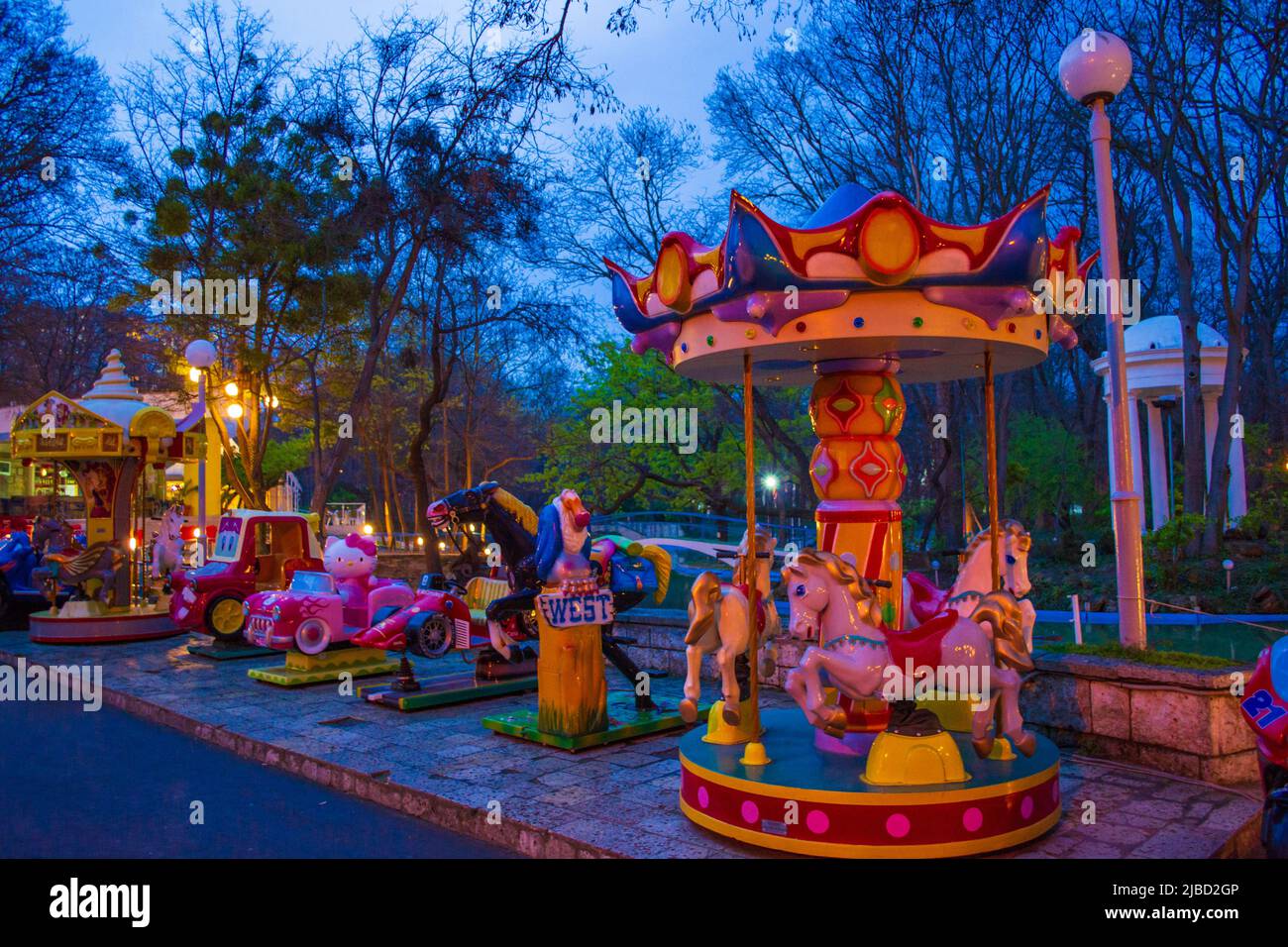 Evening view of Amusement park for children offering rides, games, activities & snacks in a playground–like setting.Varna,Sea Garden,Bulgaria Stock Photo