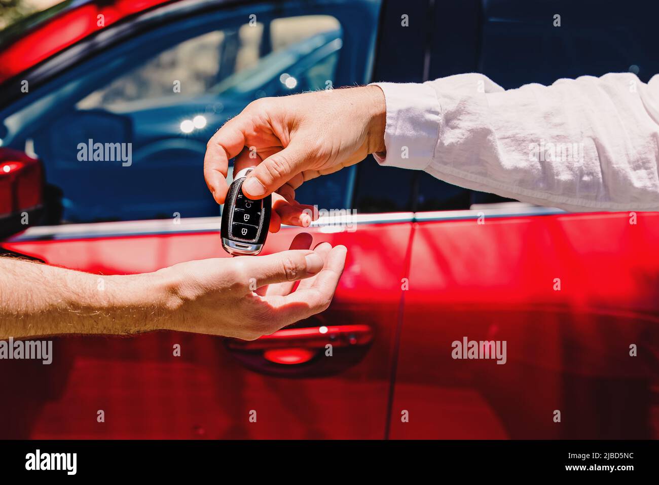 Salesperson giving car keys to the new owner. Close-up of hands on the ...