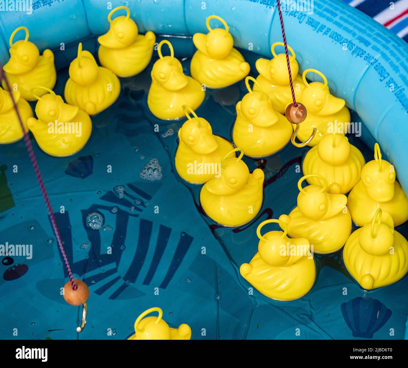Childrens hook a duck game at a village fete stock photo alamy