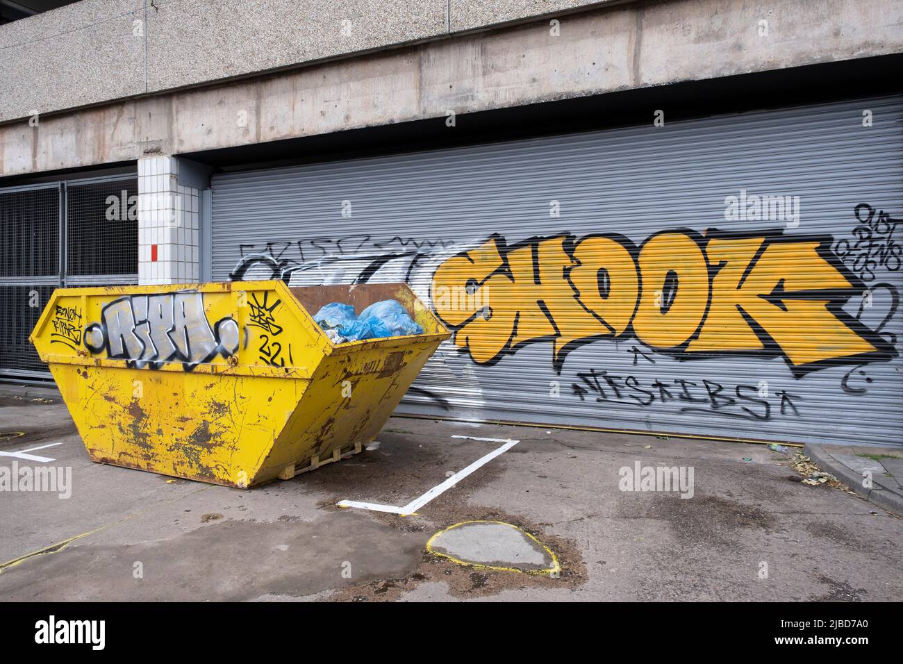 Yellow skip and graffiti on 30th May 2022 in Birmingham, United Kingdom. Stock Photo