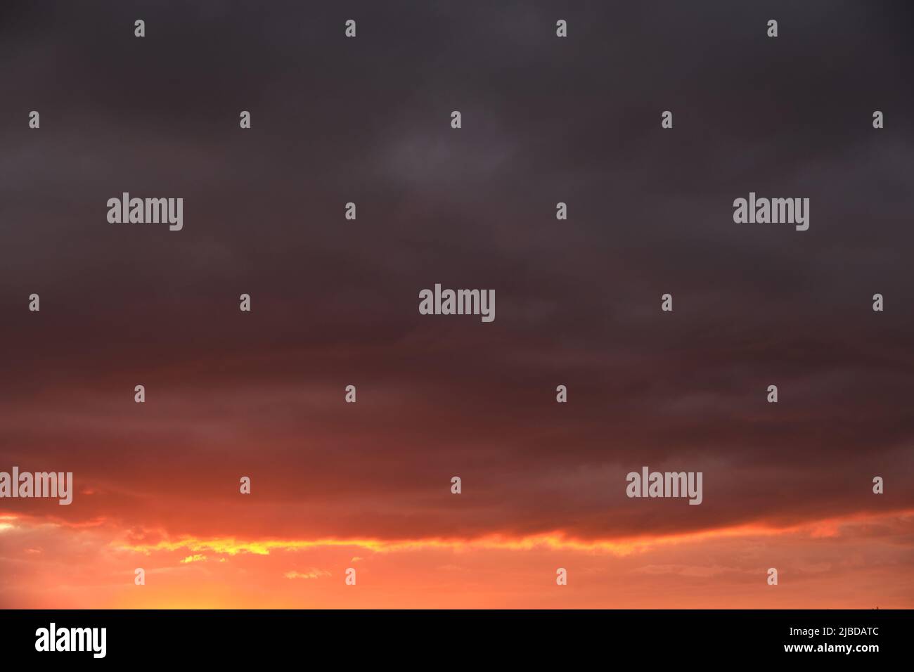 Thunderclouds with breaking rays sun at sunset Stock Photo