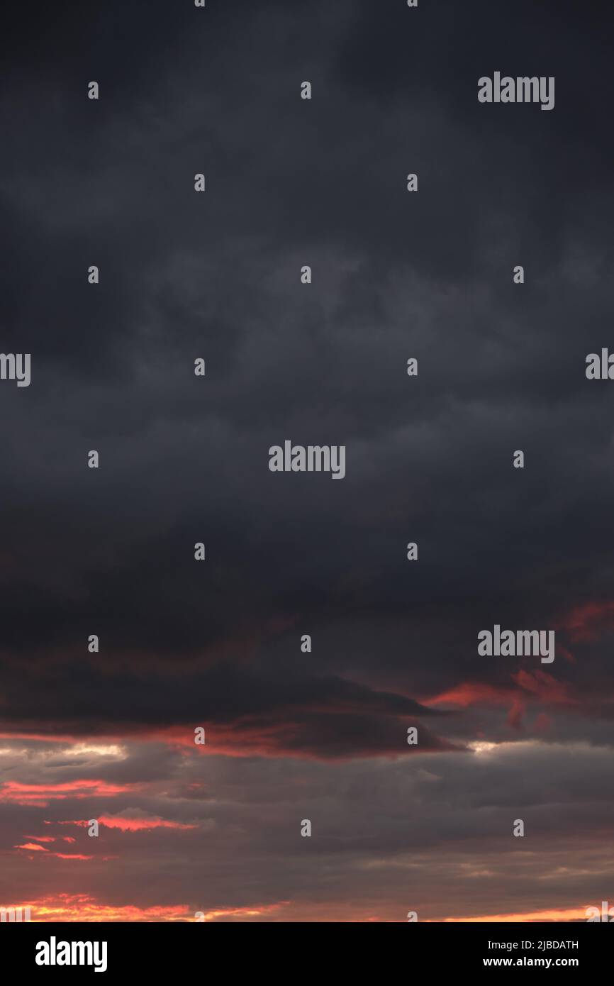 Thunderclouds with breaking rays sun at sunset Stock Photo