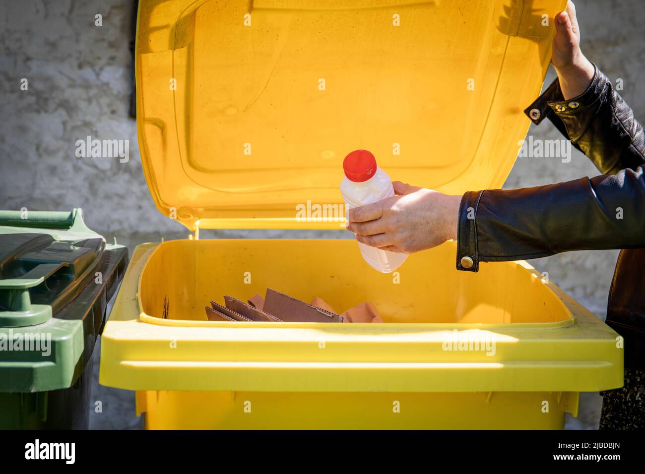 Waste sorting for recycling. Cardboard and plastic bottle in yellow container Stock Photo Alamy