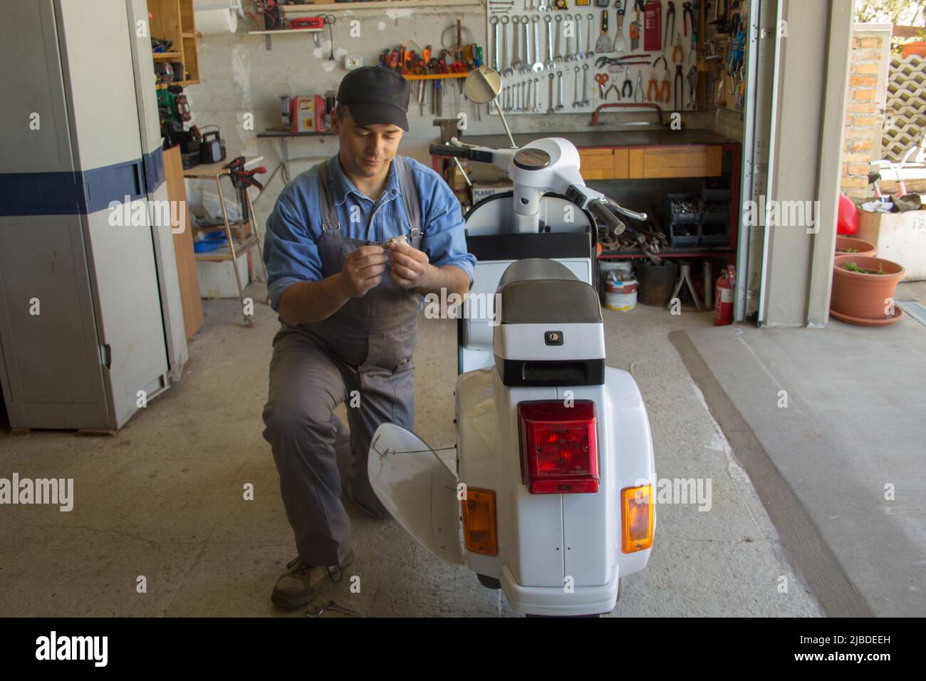 Picture of a mechanic in his replacing a spark plug on a