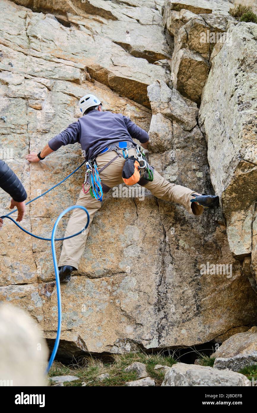 Climber starting to climb up a rock wall Stock Photo Alamy