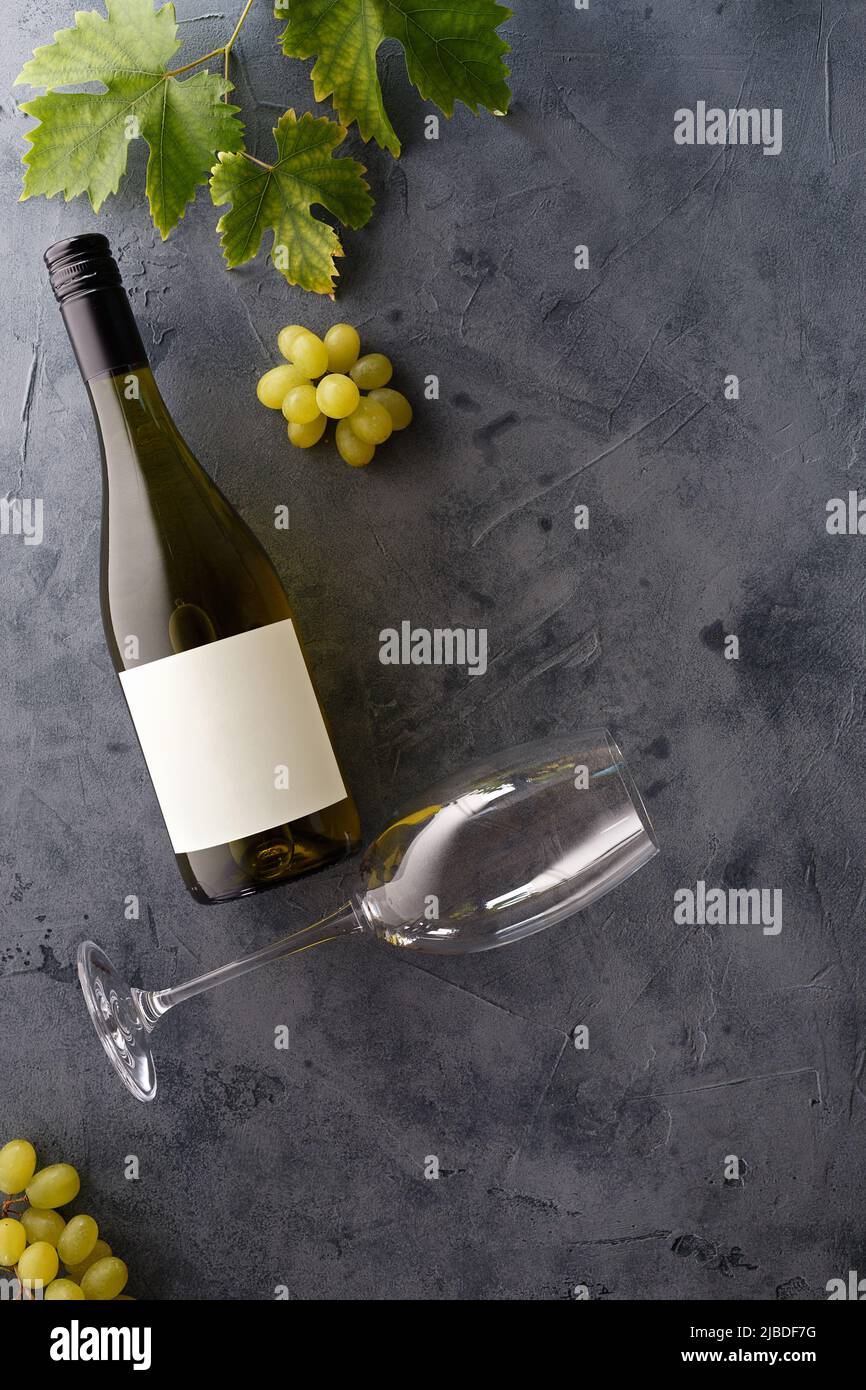 Bottle of white wine with label. Glass of wine and grape. Wine bottle mockup. Top view. Stock Photo