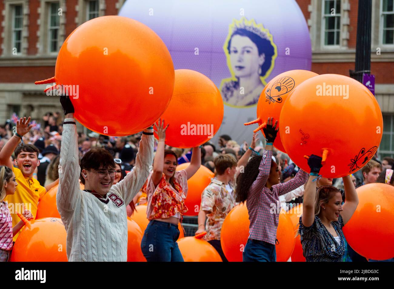 London, UK. 5 June 2022. Performers with spacehoppers pass by. The