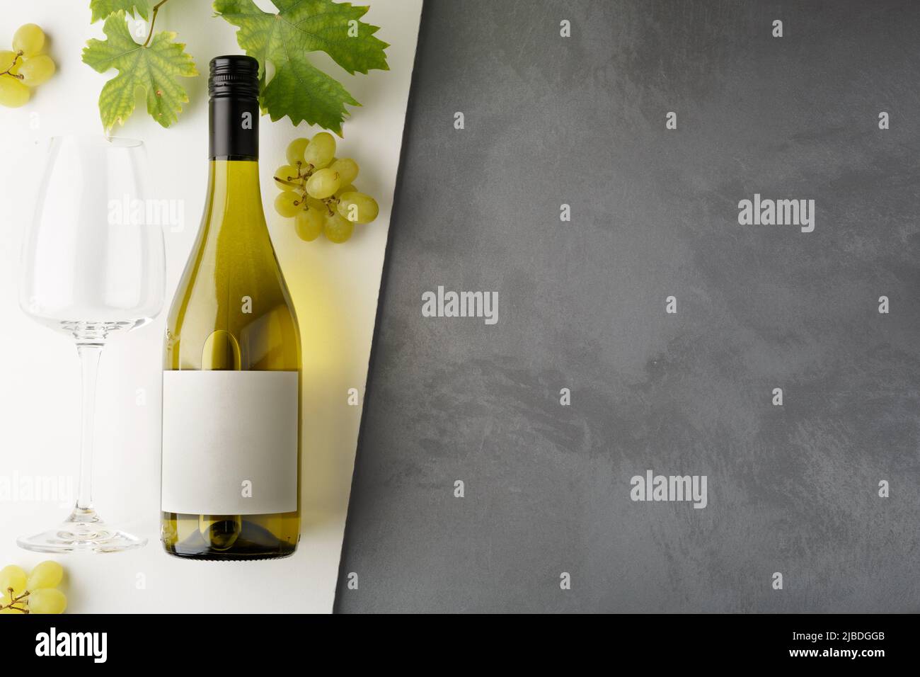 Bottle of white wine with label. Glass of wine and grape. Wine bottle mockup. Top view. Stock Photo