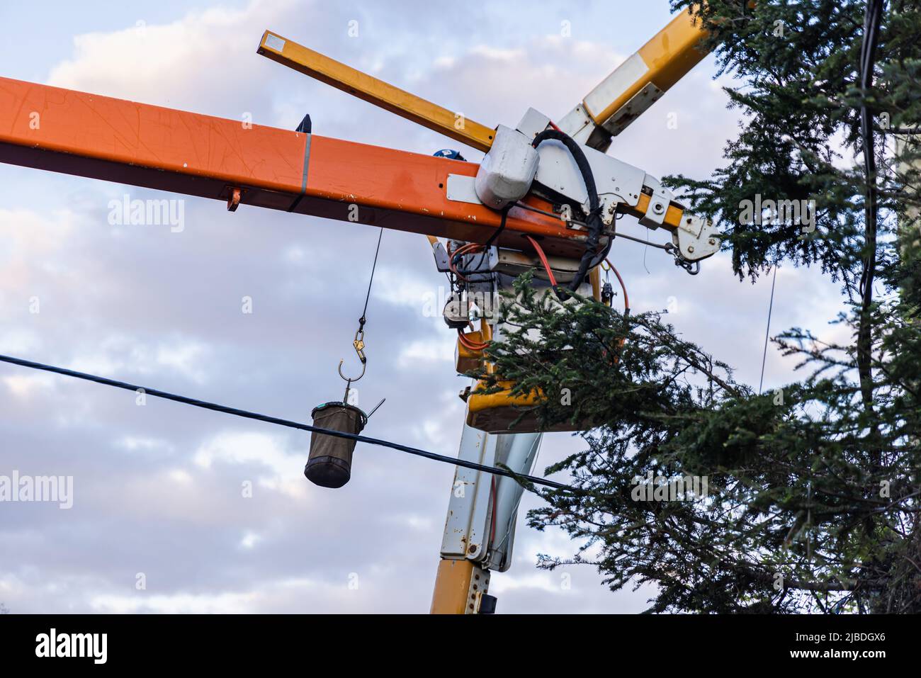 A powerline technician uses an aerial work platform to install overhead