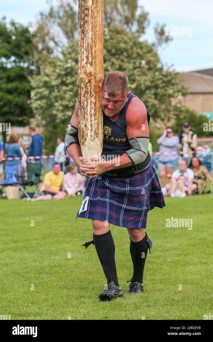 Girvan, UK. 05th June, 2022. After an absence of two years because of Covid restrictions, the Carrick Lowland Games returned to Girvan in South Ayrshire with the regular traditional highland dancing competitions, piping competitions and the ever popular heavyweight highland sports of tossing the stone, throwing the hammer, clearing the bar and tossing the caber. Some well known sports personalities attended including Neil Elliot, from Helensburgh, a former Champion of The Games. Credit: Findlay/Alamy Live News Stock Photo