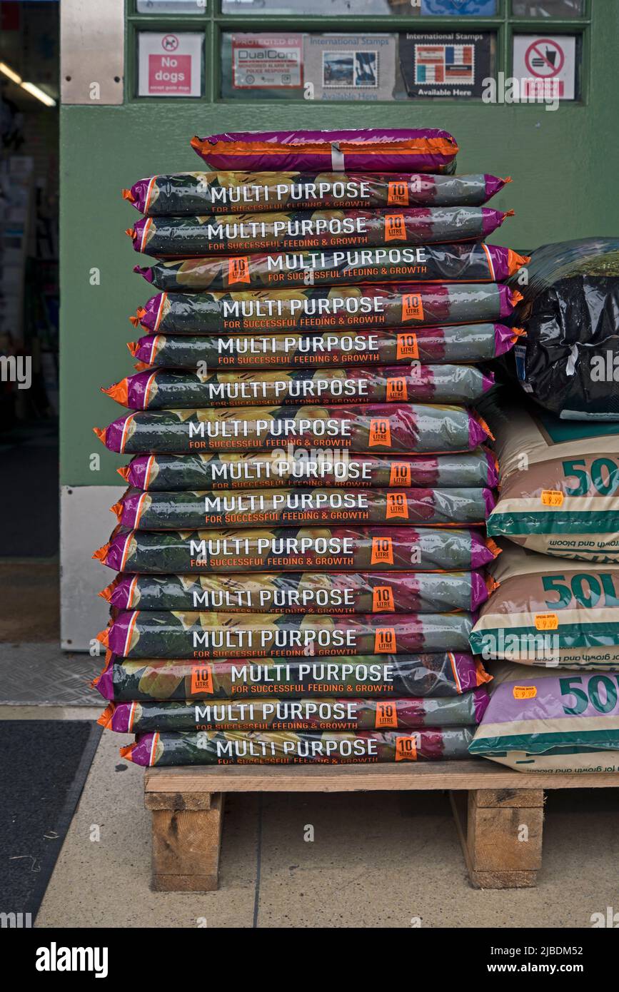 10L bags of multipurpose compost piled up on a palet. Stock Photo