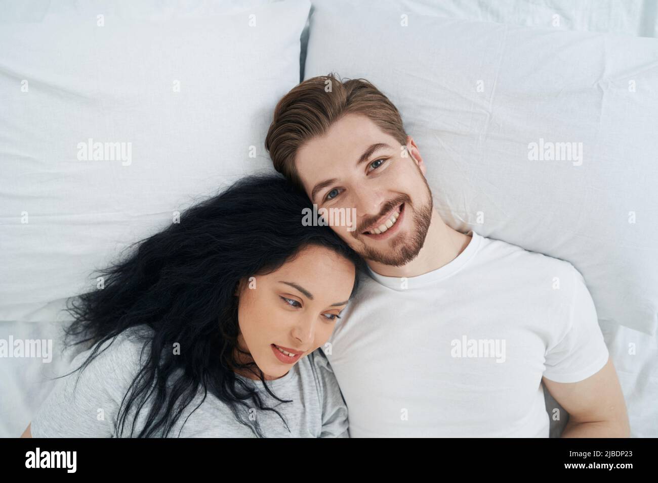Happy lady and her beloved man resting in bedroom Stock Photo
