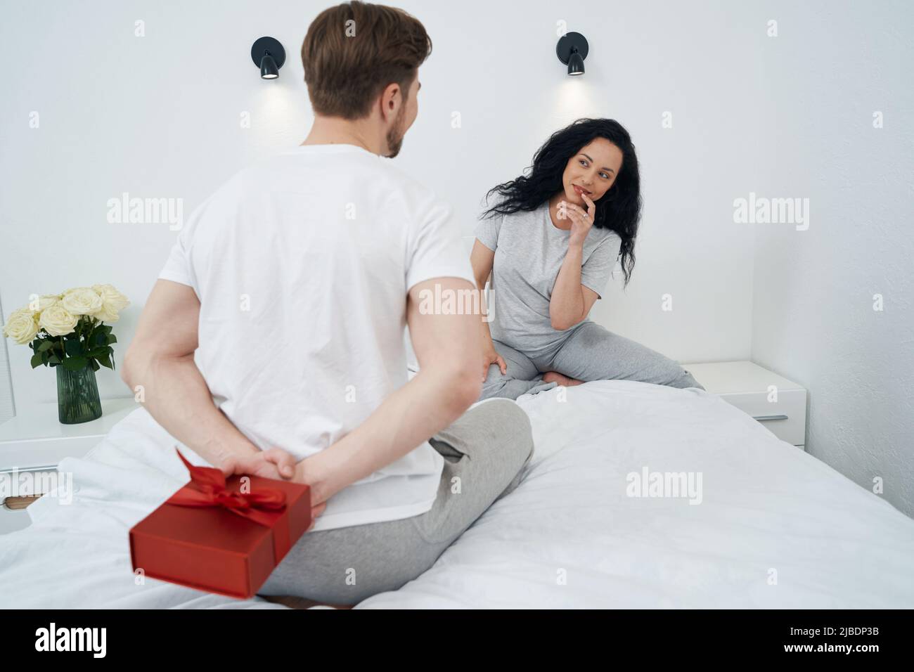 Man hiding present from his life partner Stock Photo