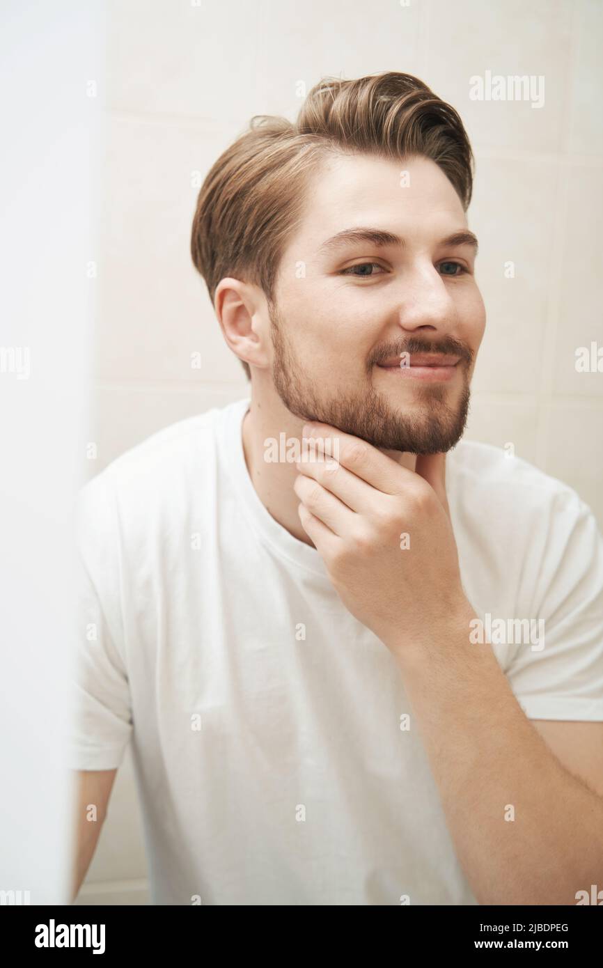 Smiling contented guy gazing at his reflection Stock Photo - Alamy