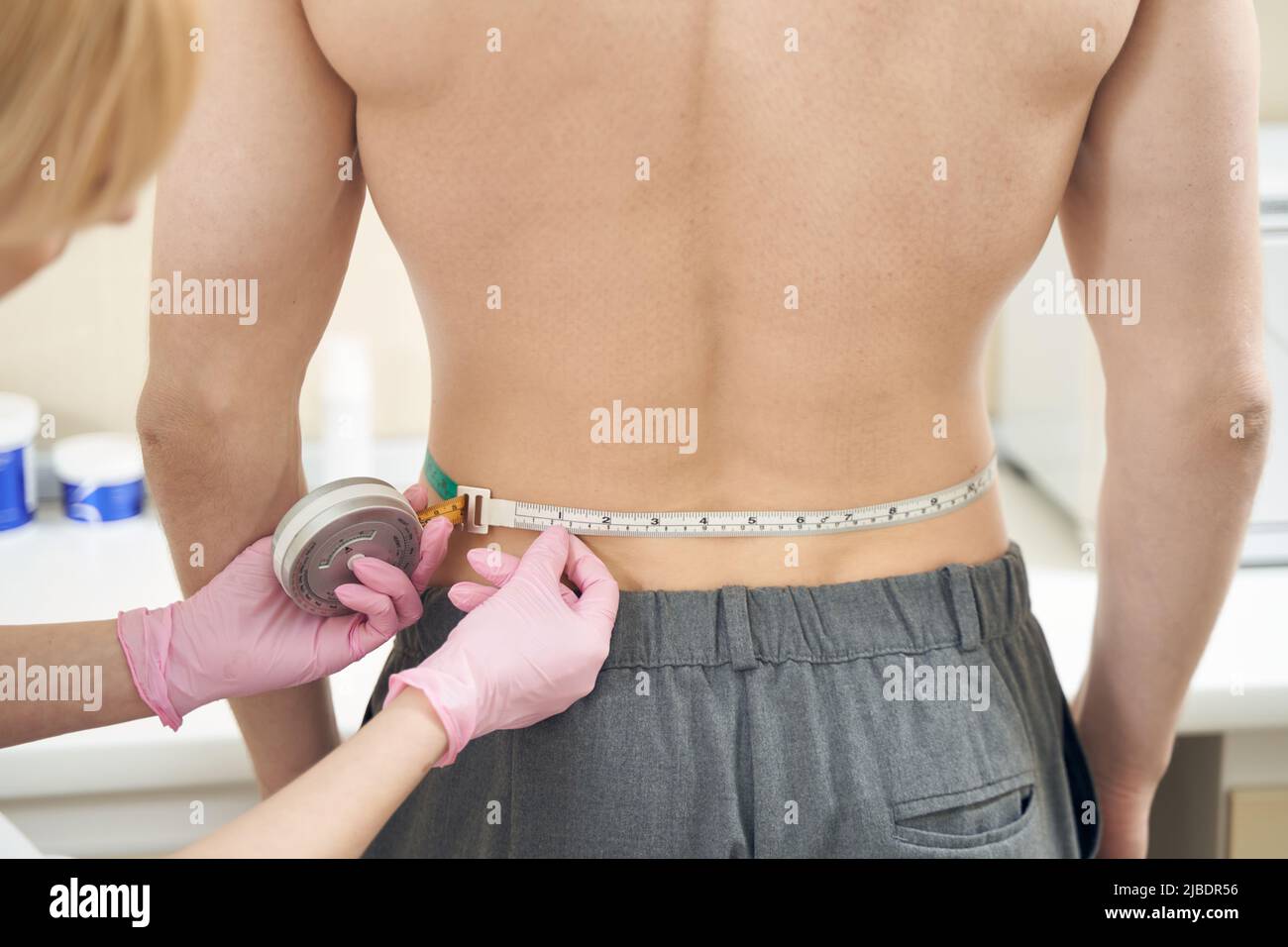 Measurring Back Beautician measuring back size with tape in beauty salon Stock Photo ...