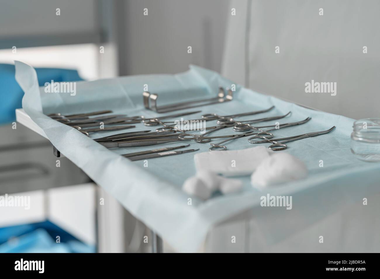 Surgical instruments and tools including scalpels forceps and tweezers arranged on table for surgery Stock Photo