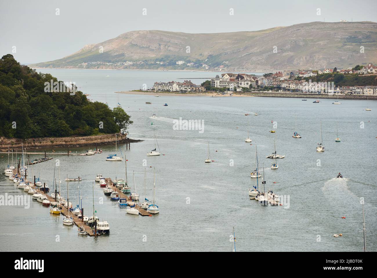 Conwy, North Wales, River Conwy waterfront pier and marina with Deganwy behind and Llandudno’s Great Orme Stock Photo