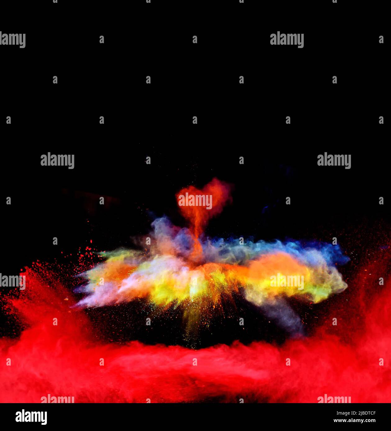 Various multicolored forms of powder paint explode in front of a black ...