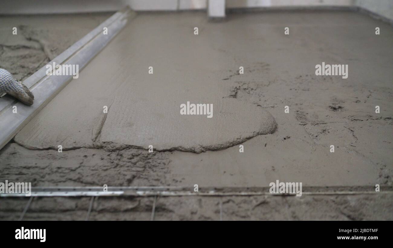 Construction work, concrete cement plaster. Using a spatula, level or
