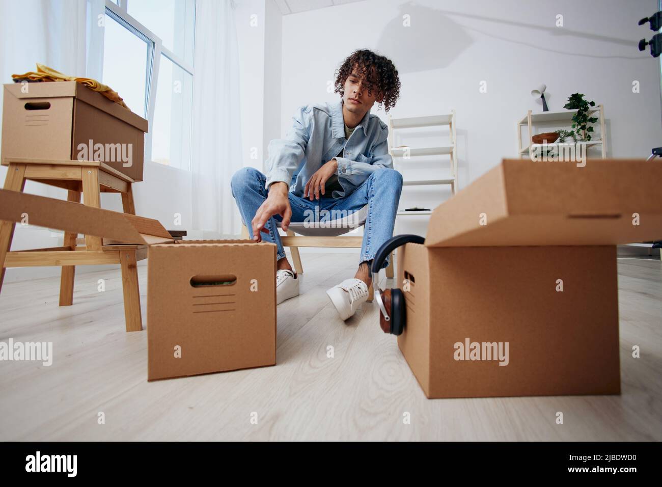 portrait of a man unpacking things from boxes in the room sorting