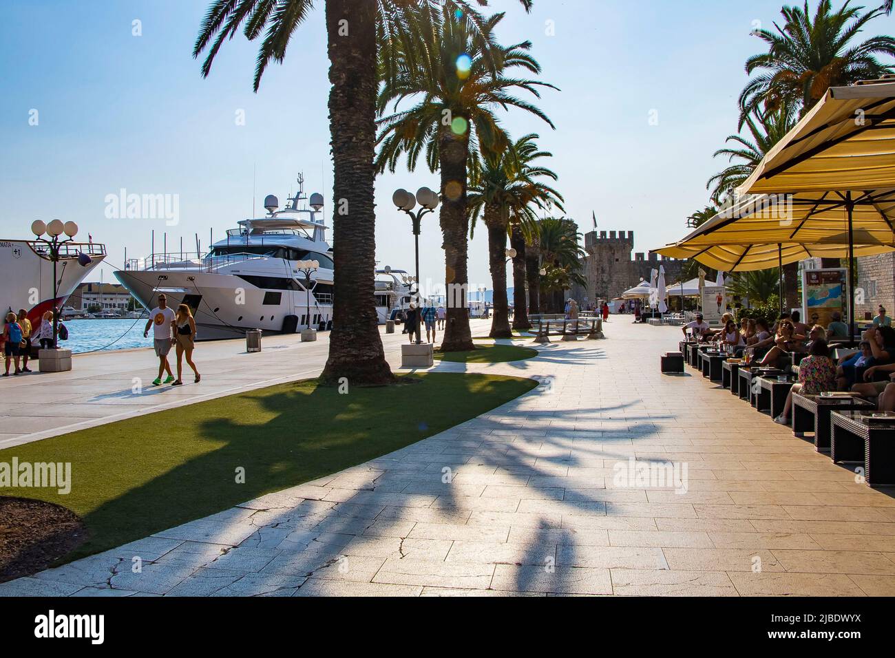 Sunny promenade along the pier of old Venetian town, Trogir, Croatia. Stock Photo