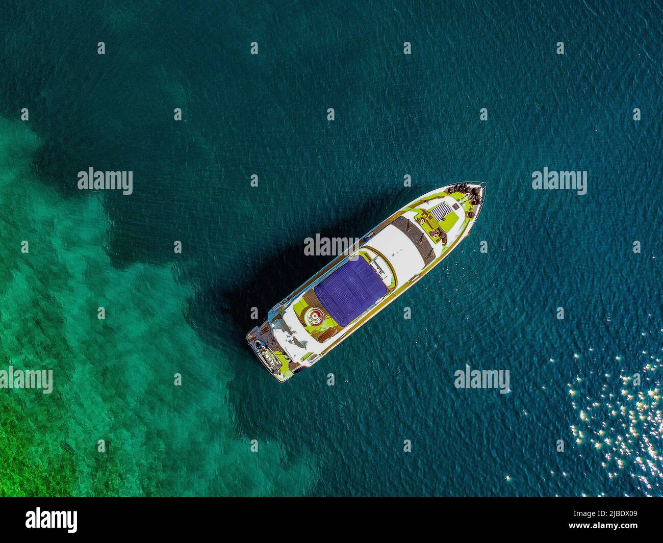 Aerial drone top down ultra wide photo of luxury yacht anchored in tropical exotic island bay with crystal clear turquoise sea. Stock Photo